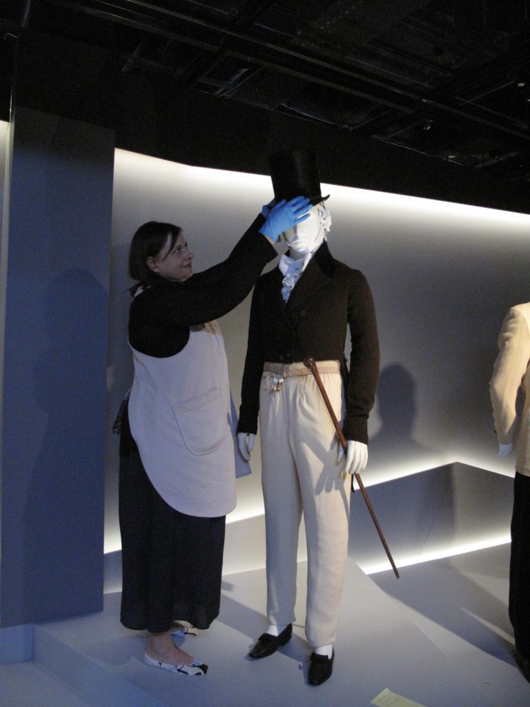 Melinda Kerstein, Costume Installation Specialist (LACMA) adding the silk plush Top hat